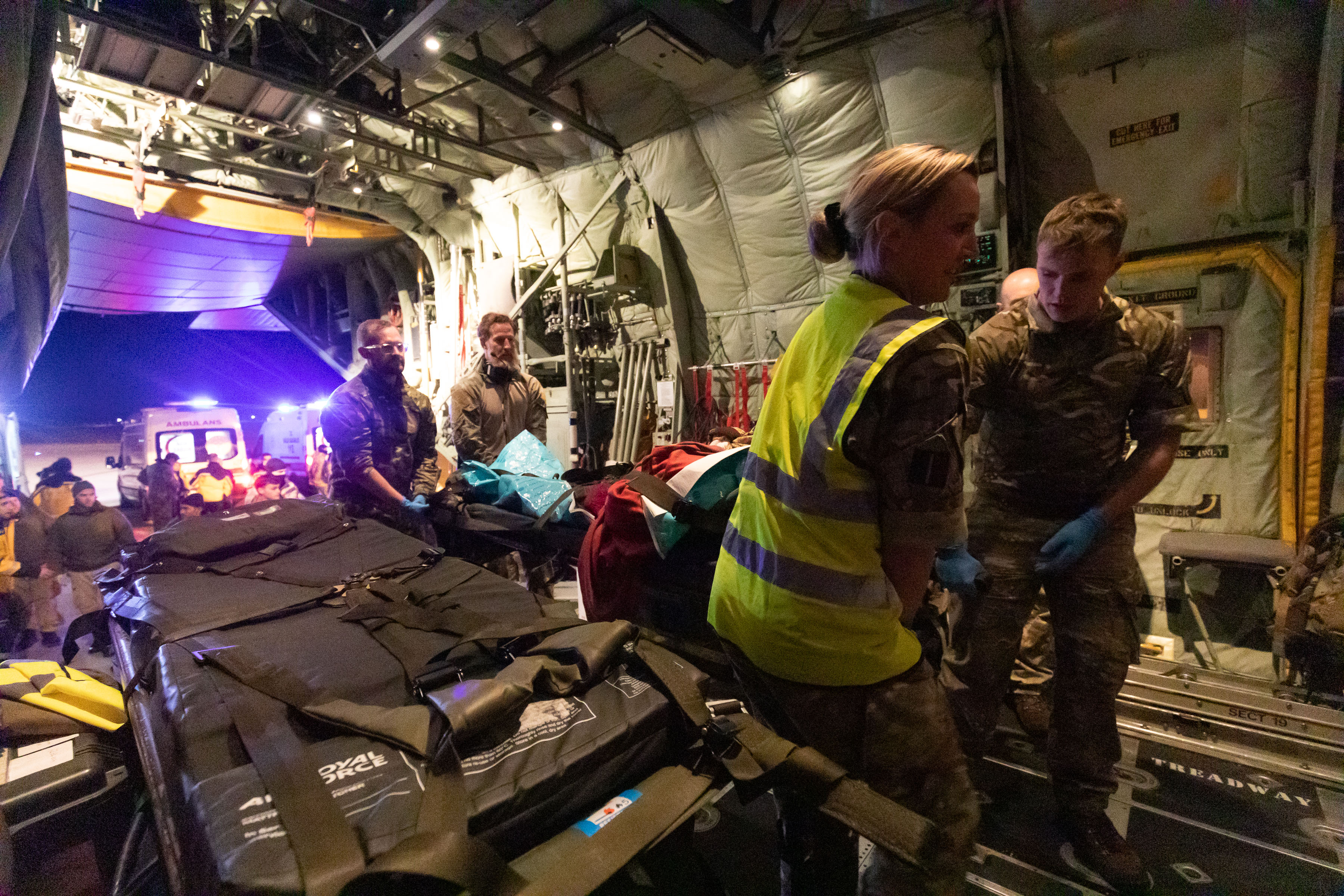 Image shows RAF medics attending to patient inside RAF Hercules aircraft.